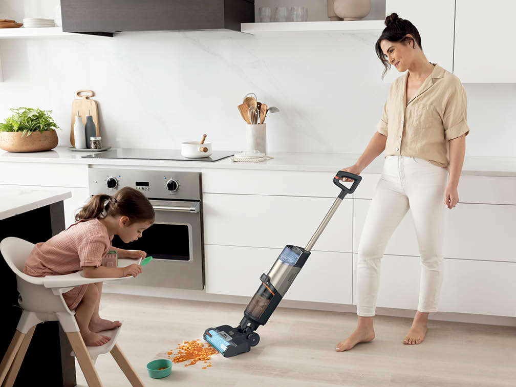 Immagine di una mamma che pulisce con la lavapavimenti Shark HydroVac dei cereali versati per terra dalla figlia