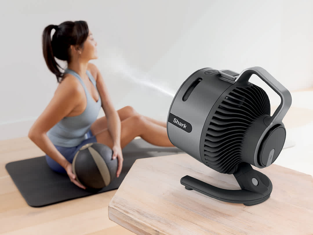 Immagine del ventilatore Shark FlexBreeze HydroGo che rinfresca una donna che fa yoga