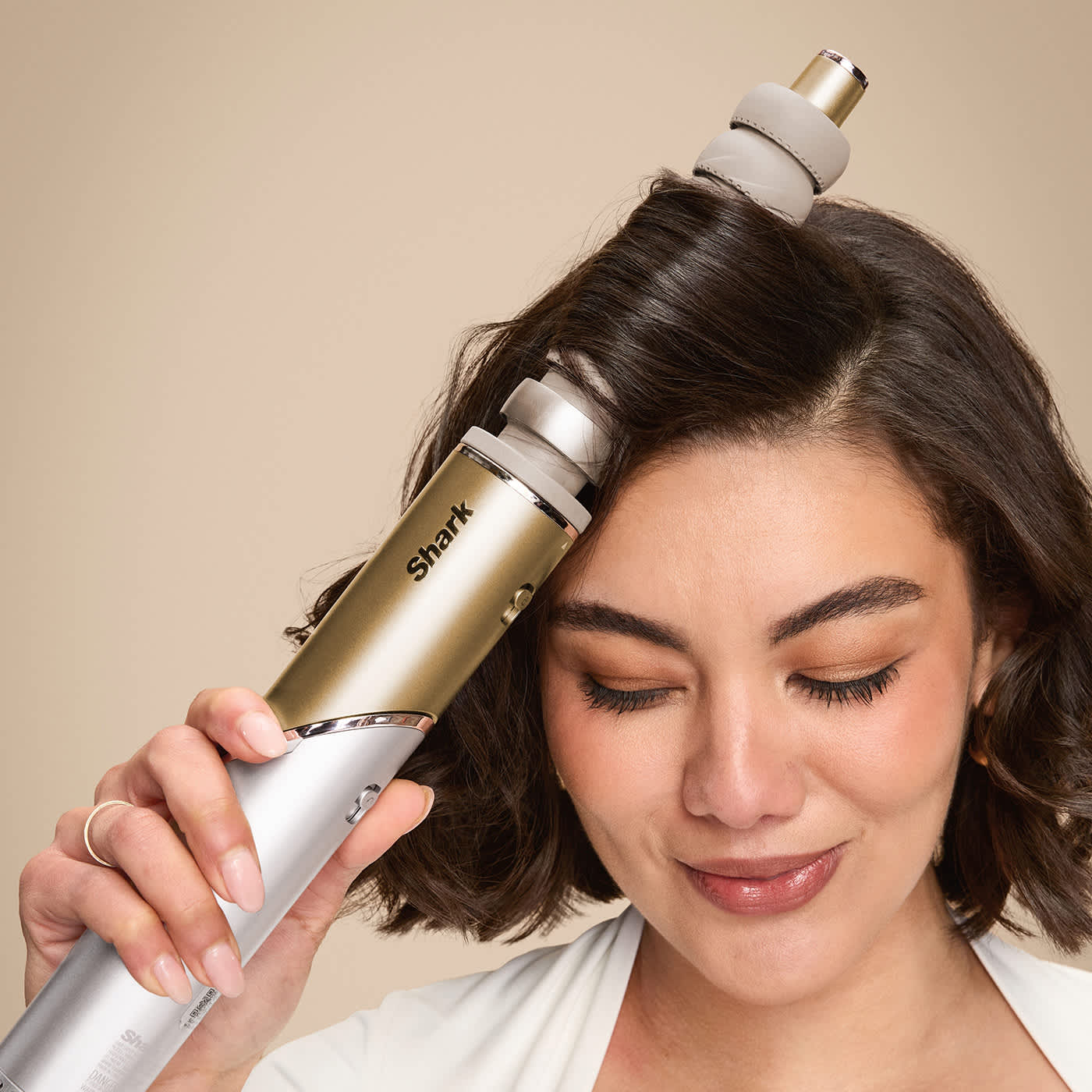 Ragazza che si arriccia i capelli con i cilindri autoavvolgenti di Shark Glam