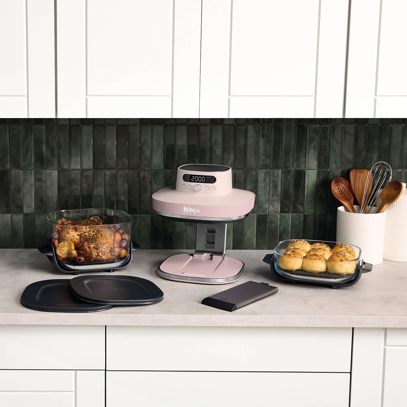 Air fryer Ninja Crispi Pro AS101EU stojący na blacie kuchennym, obok dwa szklane naczynia CleanCrisp o pojemności 5,7 l i 2,3 l z r&oacute;żnymi upieczonymi potrawami w środku