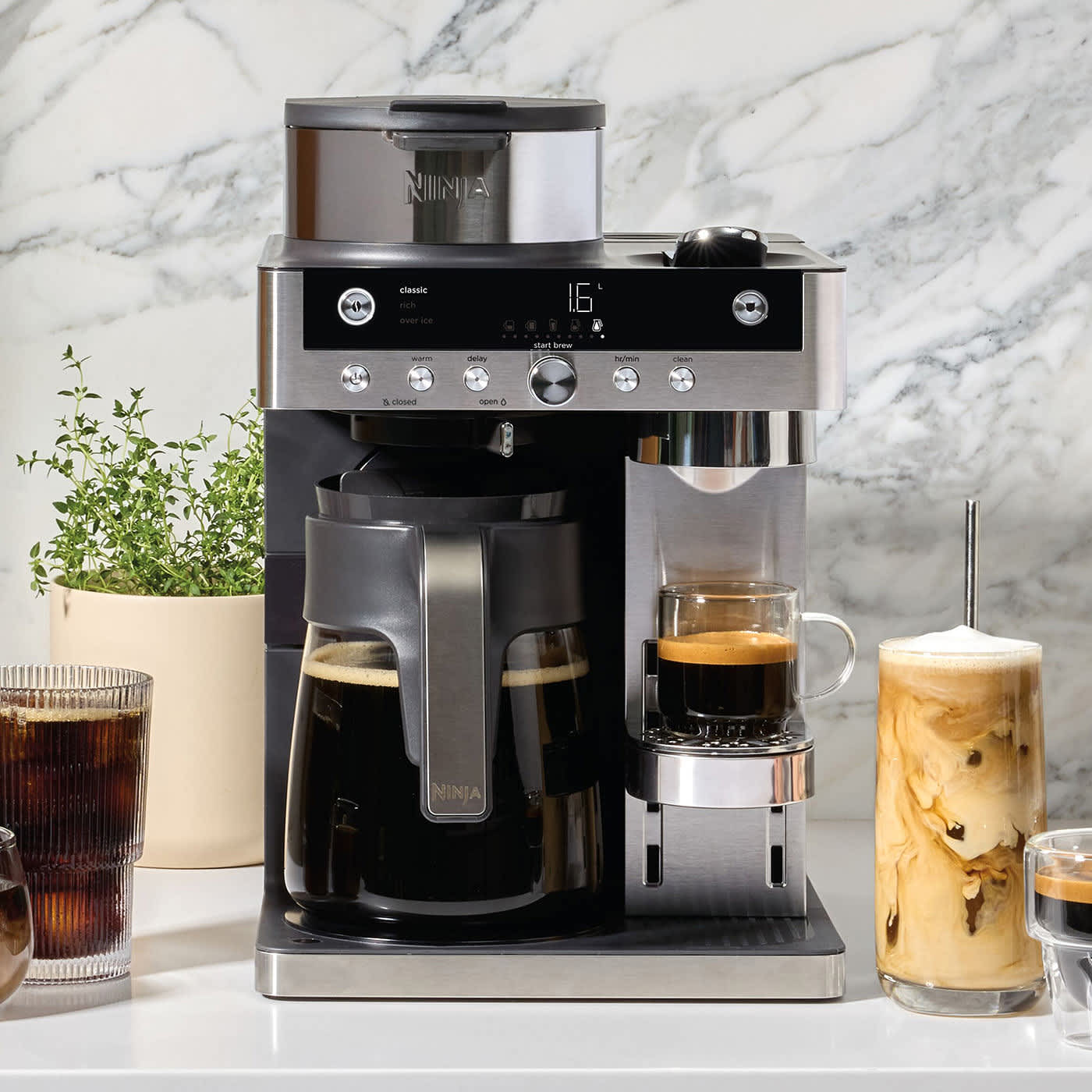 Machine &agrave; caf&eacute; Ninja avec caf&eacute; filtre et espresso, entour&eacute;e de tasses de caf&eacute; glac&eacute;.