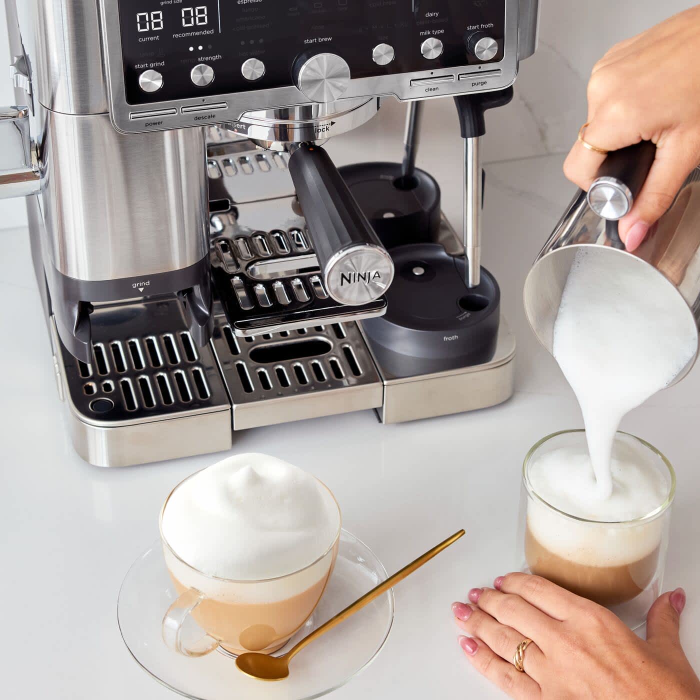 Osoba spienia mleko przy pomocy ekspresu do kawy Ninja Luxe Caf&eacute; Pro ES701EU