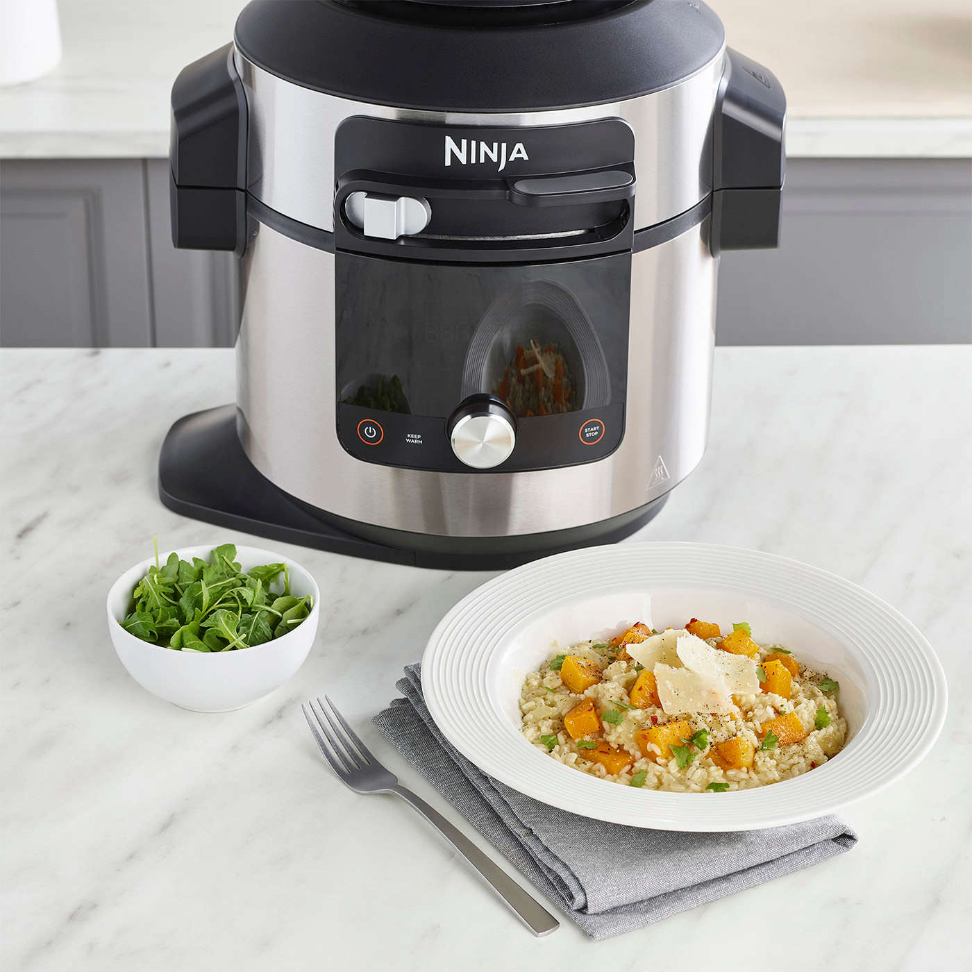 Multicooker Ninja Foodie MAX SmartLid 14 w 1 OL750EU stojący na blacie w kuchni z gotowym posiłkiem obok na talerzu