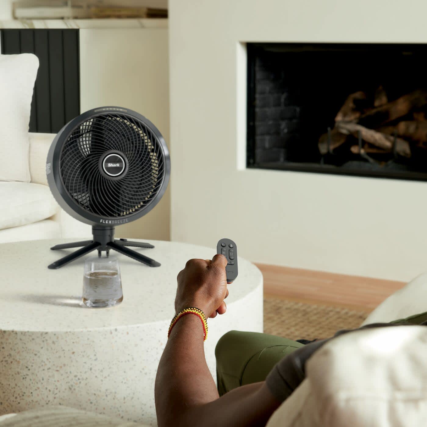 Personne utilisant une t&eacute;l&eacute;commande pour contr&ocirc;ler un ventilateur Shark.