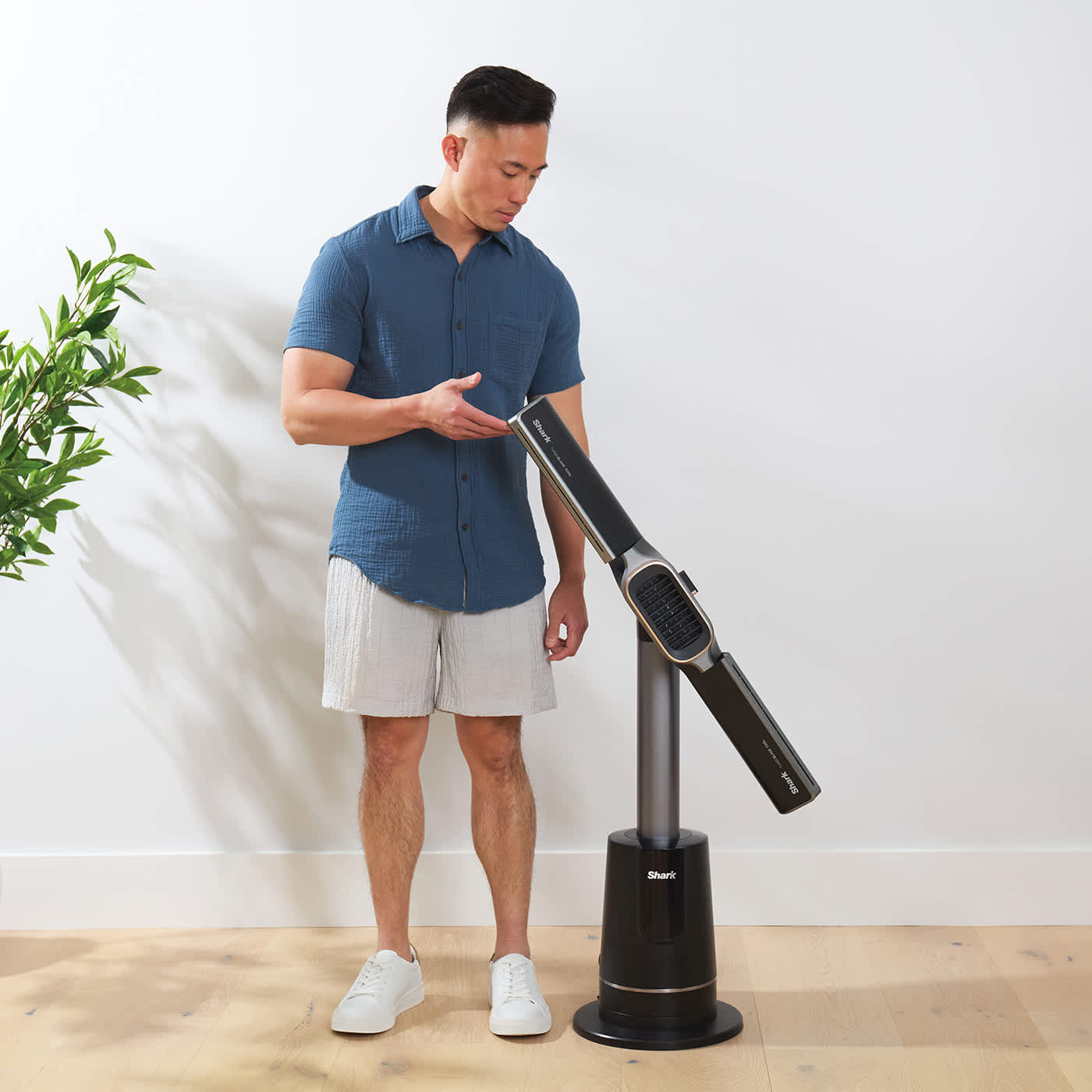 Mężczyzna zmienia tryp pracy z poziomego w pionowy termowentylatora Shark TurboBlade Cool + Heat wentylator i nagrzewnica TH200EU