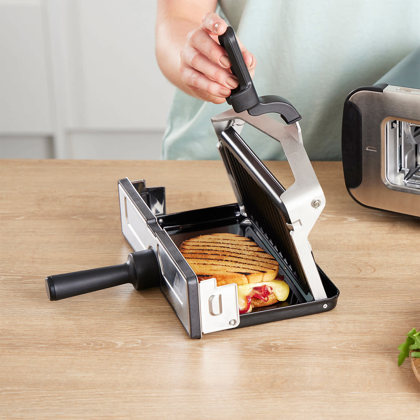 Mężczyzna wyjmuje gotowe upieczone panini z tostera Ninja Foodi