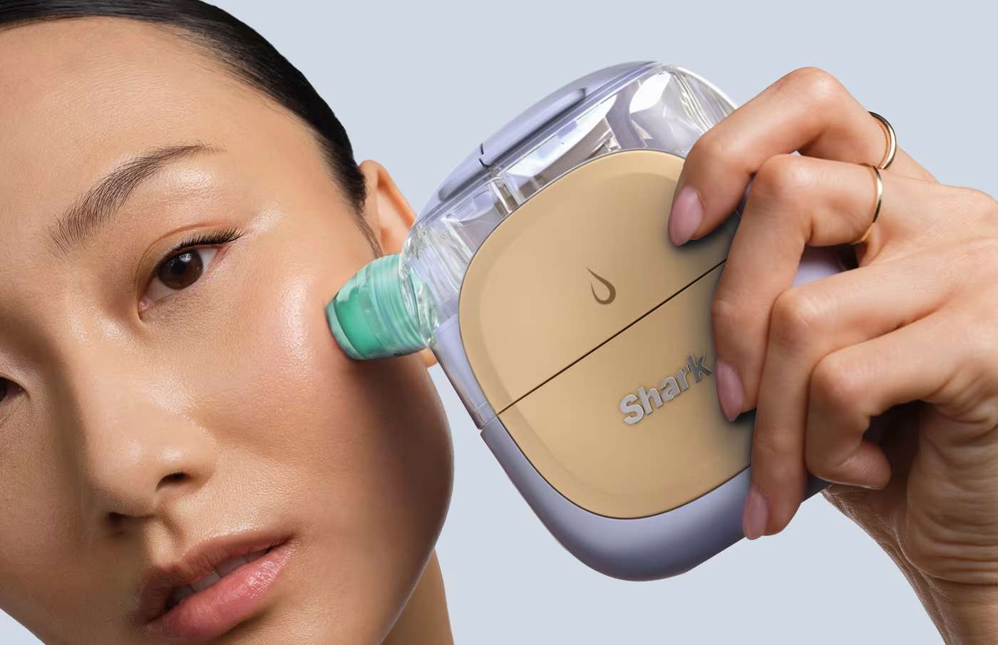 Kobieta przykłada do policzka hydroaktywny system domowej pielęgnacji twarzy Shark FacialPro Glow FH320EU