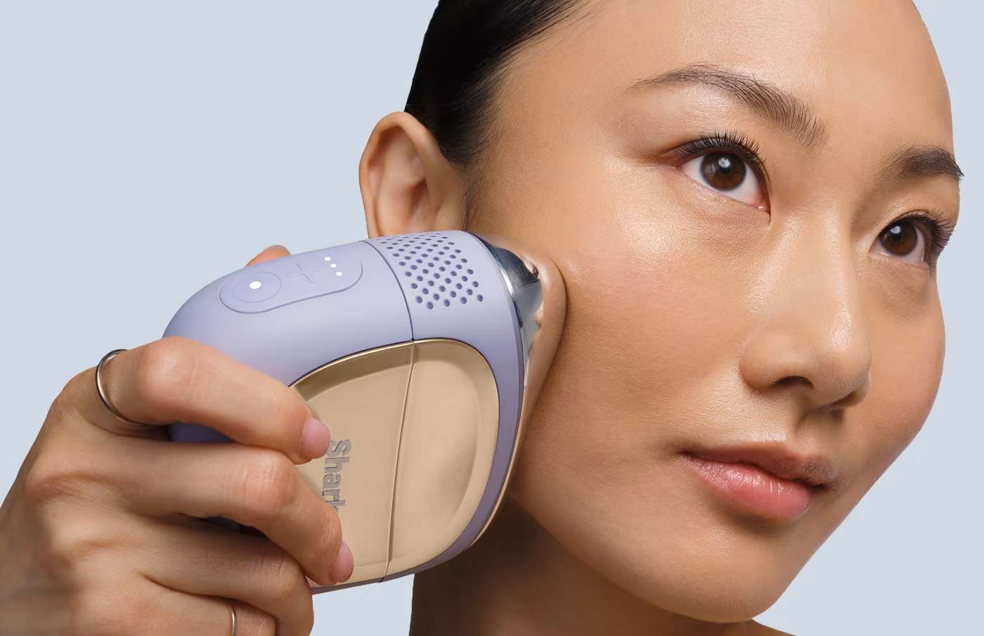 Kobieta przykłada hydroaktywny system domowej pielęgnacji twarzy Shark FacialPro Glow FH320EU z końc&oacute;wką DePuffi