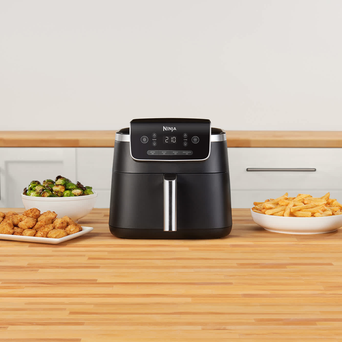 Air Fryer Ninja sobre una encimera con muchos platos cocinados distintos