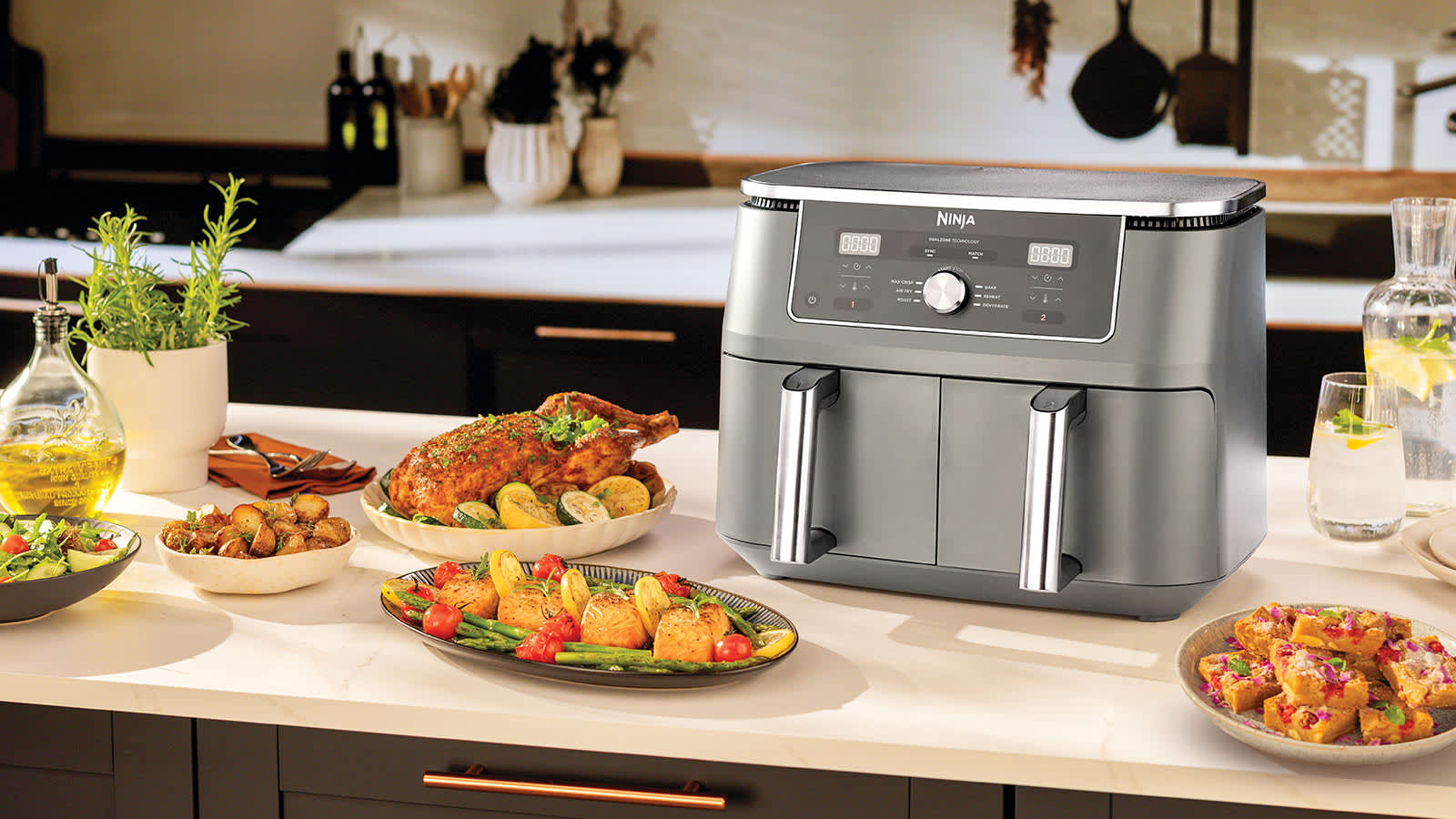 Air fryer sur une table avec des assiettes de nourriture.