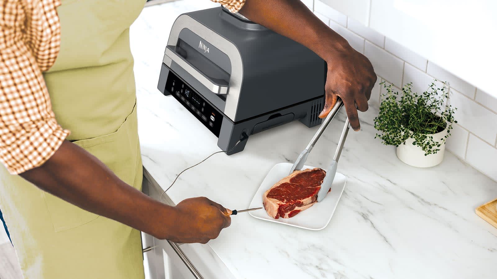 Hombre colocando el term&oacute;metro de cocci&oacute;n a un trozo de carne