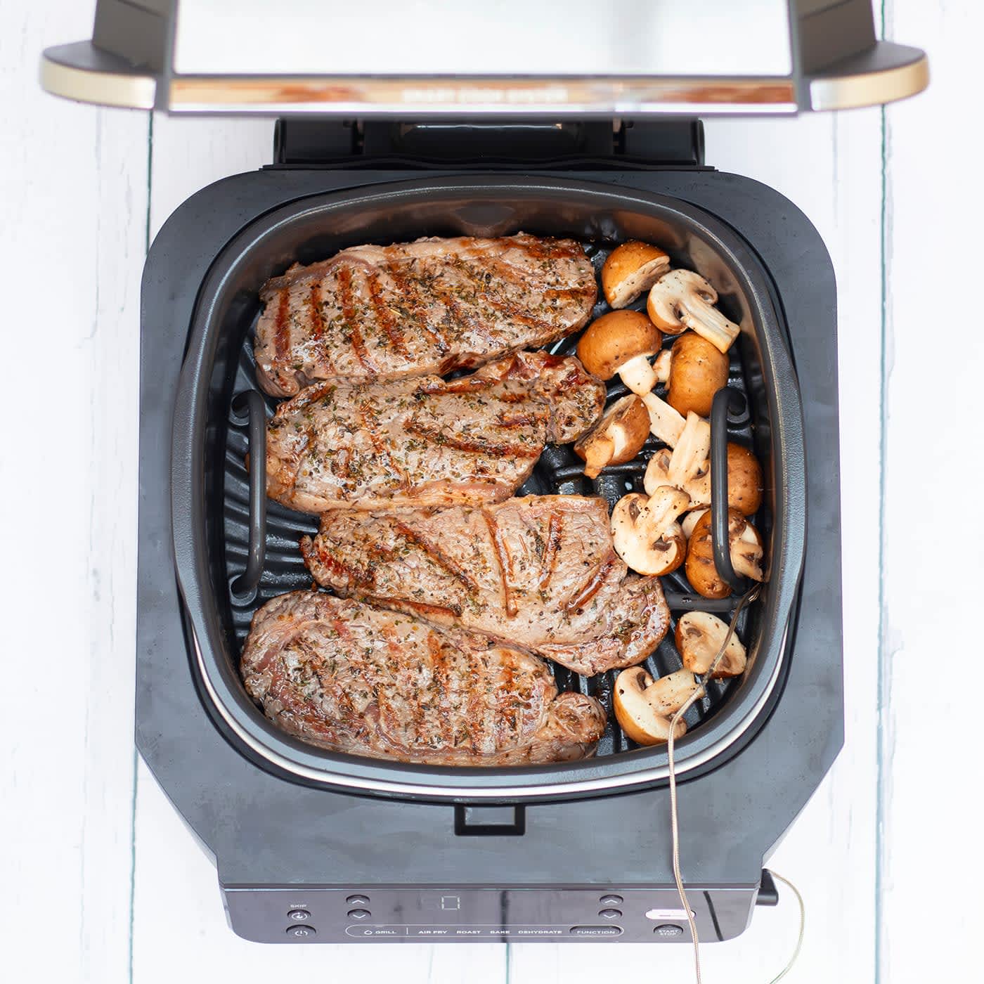 Cocinando 4 filetes de carne en el grill NInja