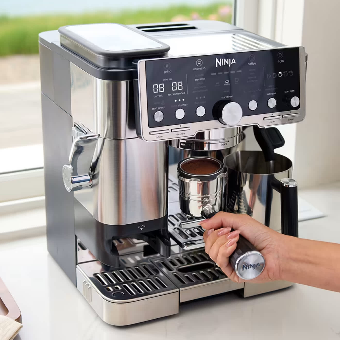 Personne pr&eacute;parant un expresso avec la machine &agrave; caf&eacute;.