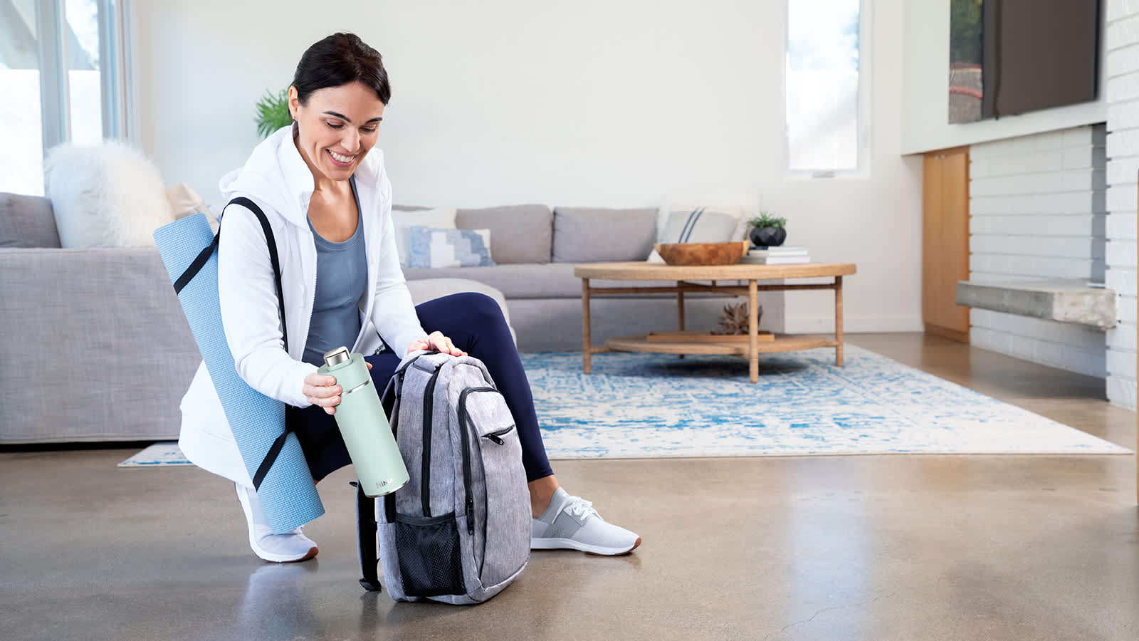 Femme rangeant sa gourde dans son sac &agrave; dos