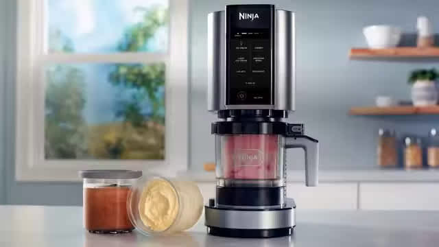 Ninja Creami sur une table avec deux pots de glace.