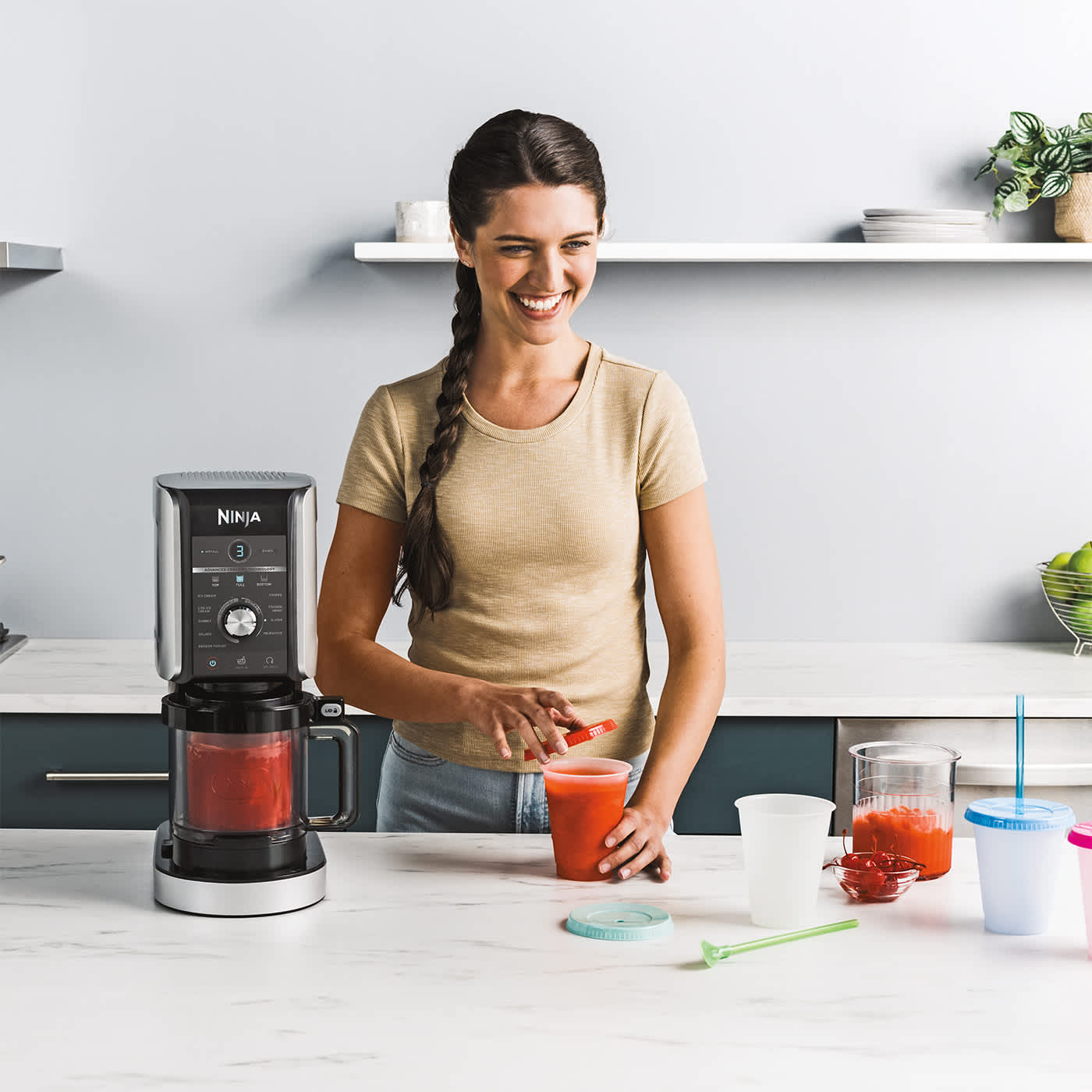 Femme pr&eacute;parant des smoothies avec la machine &agrave; glace Ninja.