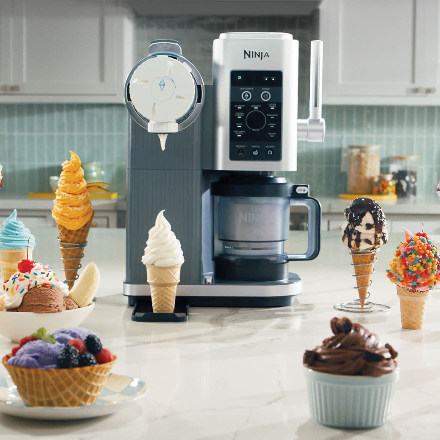 Heladera ninja creami swirl sobre una encimera con muchos postres frios alrededor