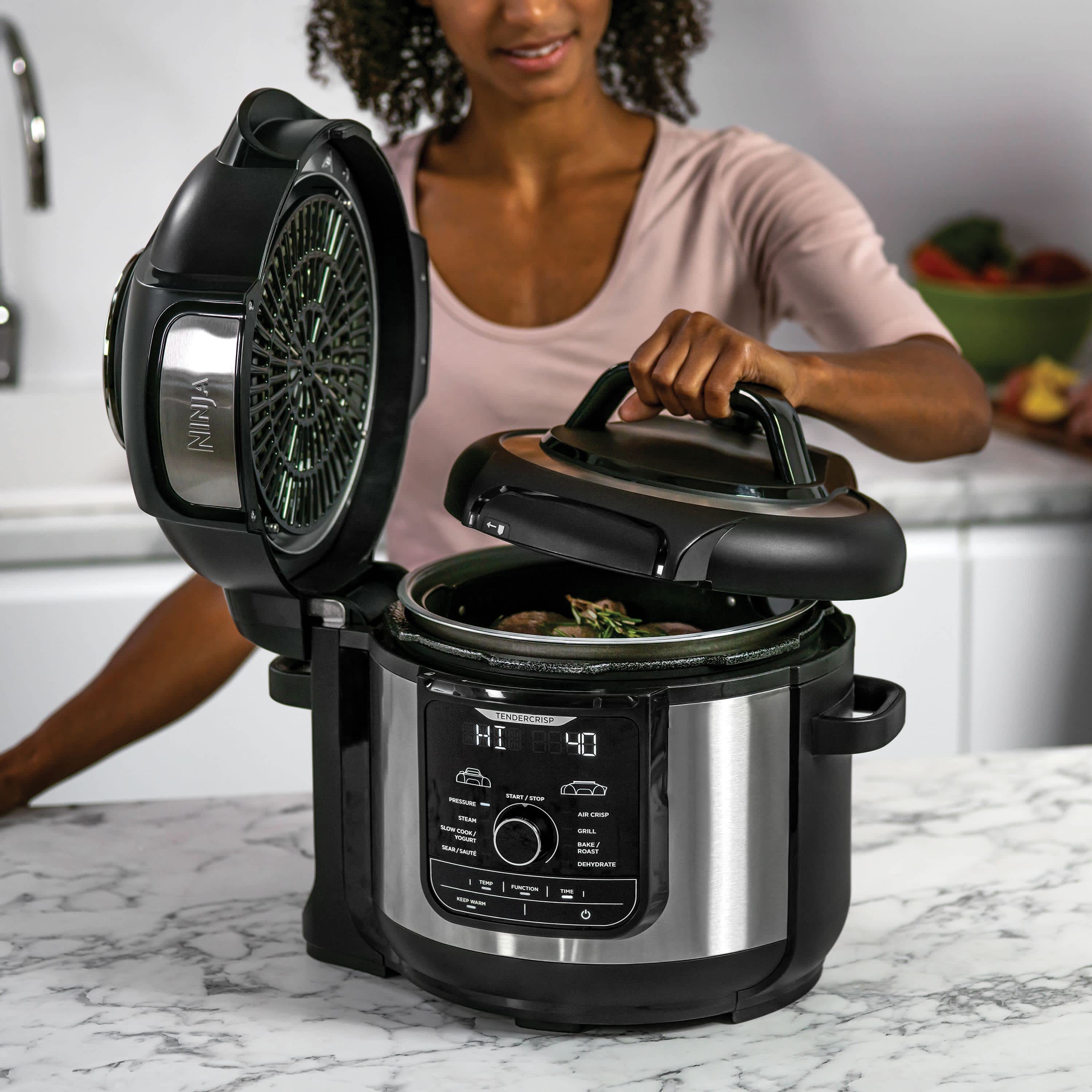 mujer cocinando con una olla ninja