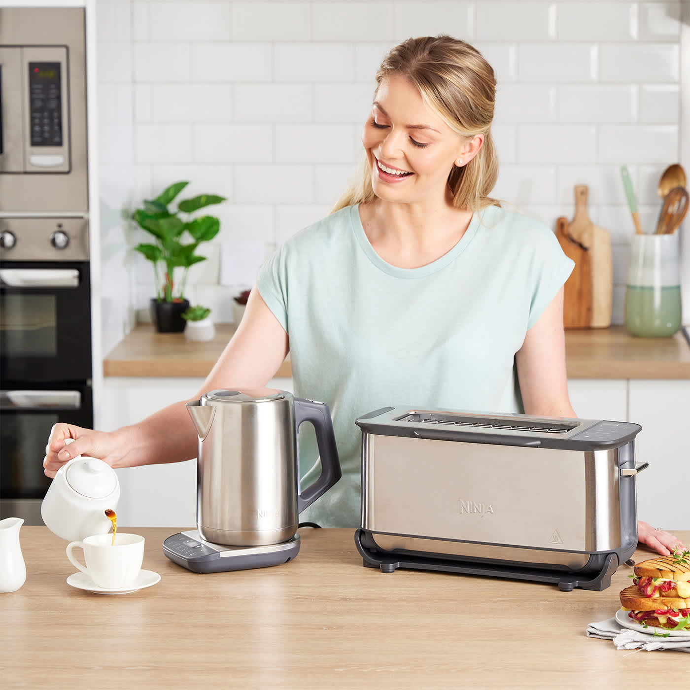 mujer usando una tostadora y una kettle Ninja