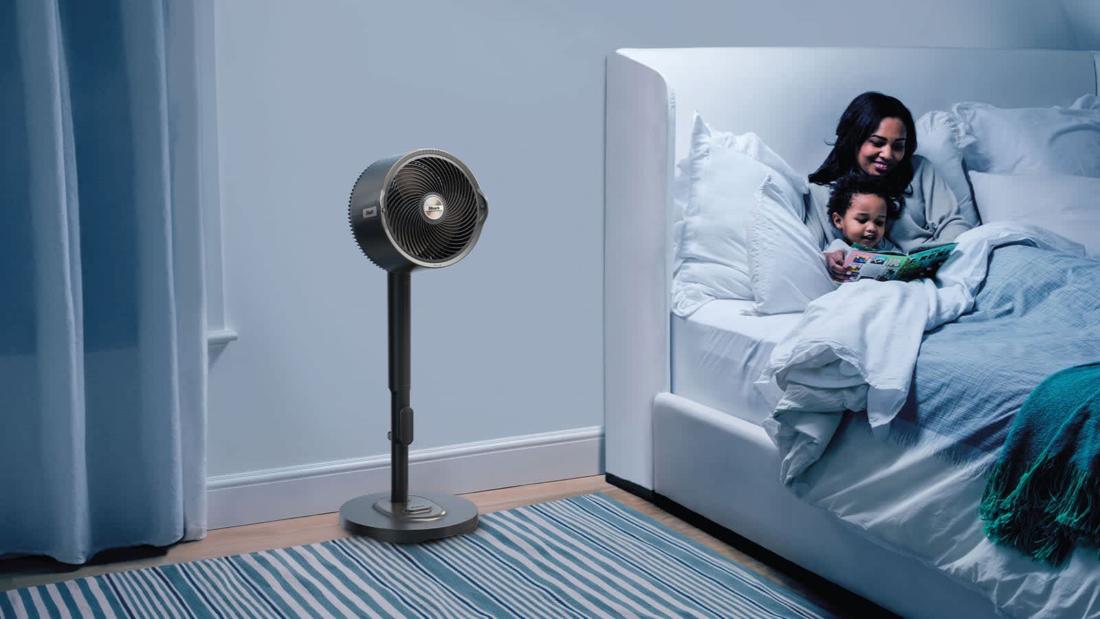 ventilador en una habitaci&oacute;n con madre e hija en la cama