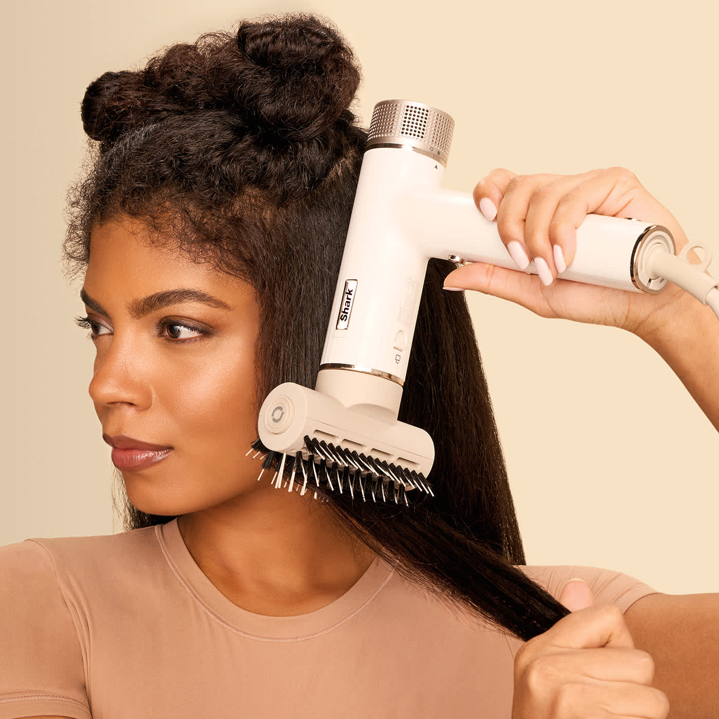 Mujer con pelo largo alis&aacute;ndose el cabello con el secador shark