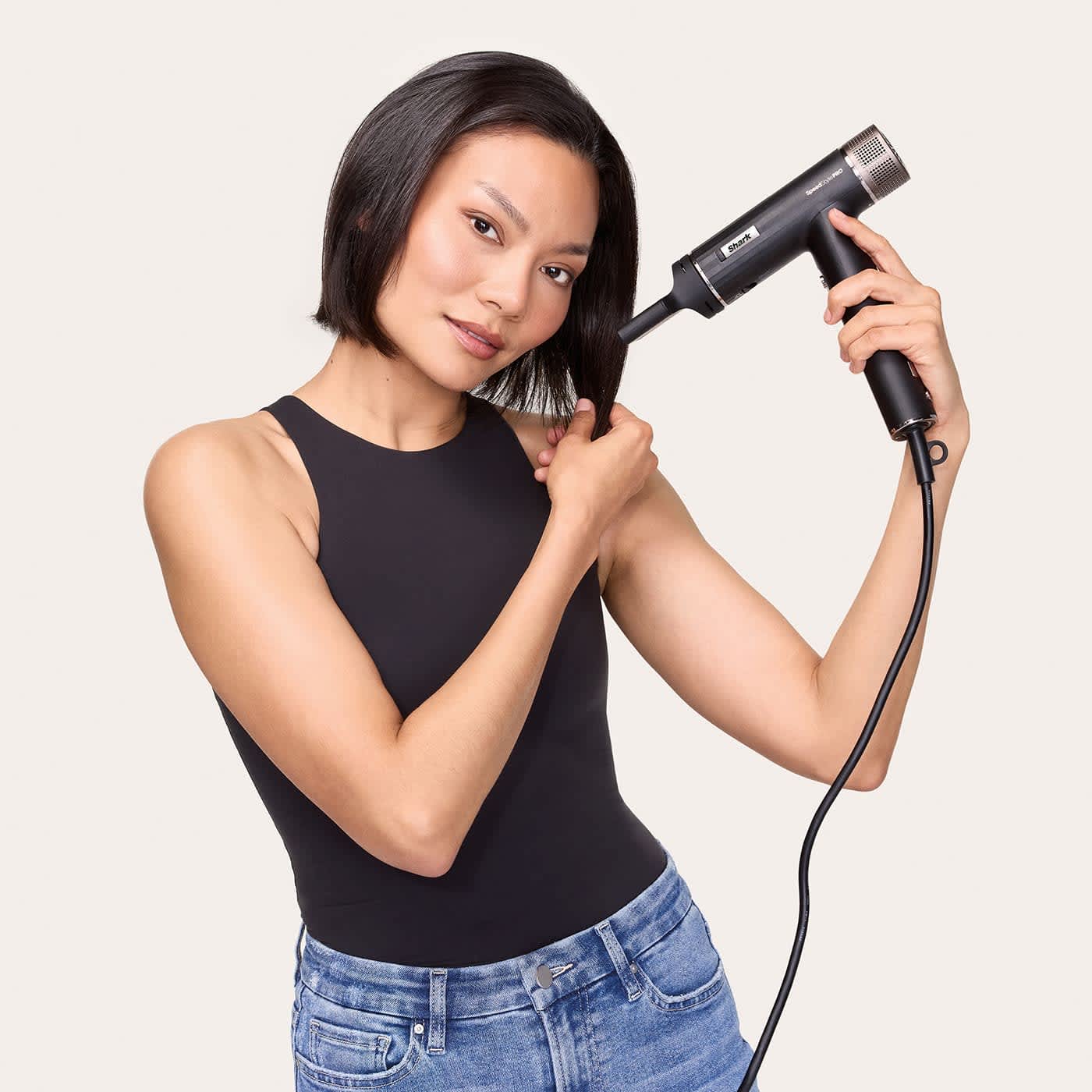 Femme se s&eacute;chant les cheveux avec un s&egrave;che-cheveux Shark.