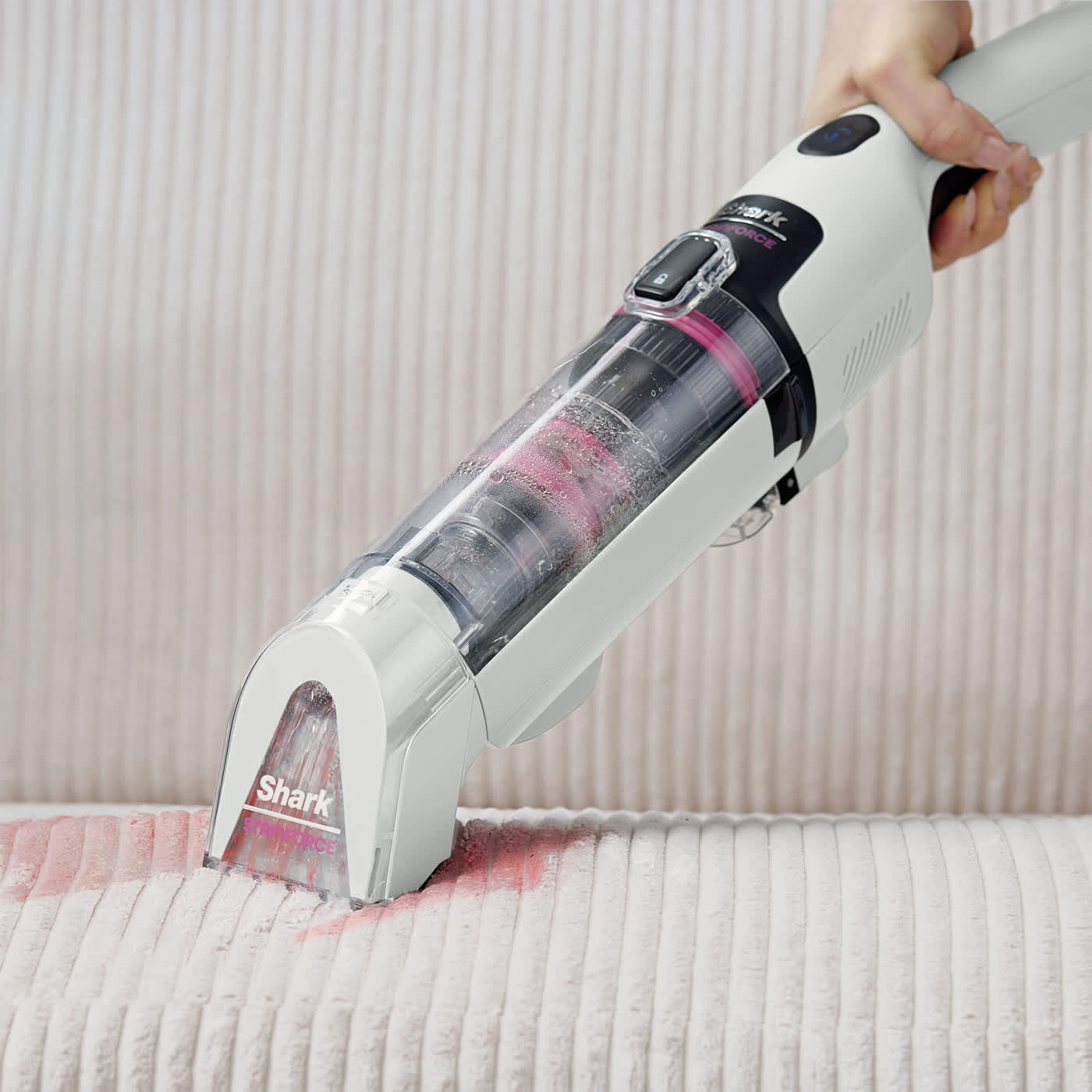Personne retirant une tache sur un tapis avec Shark StainForce.