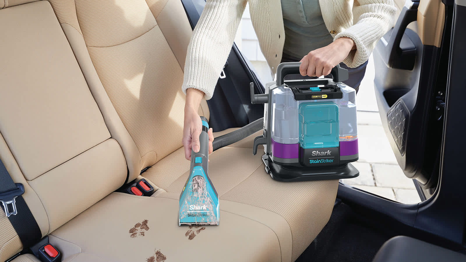 mujer limpiando huellas de perro de tapicer&iacute;a de coche