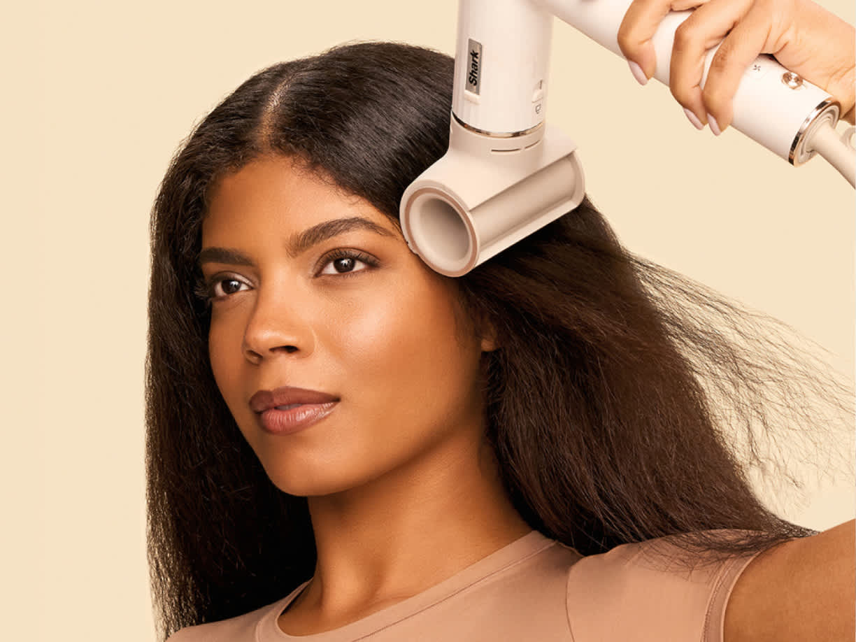 Mujer con el Cabezal antiencrespamiento del moldeador de pelo shark flexstyle