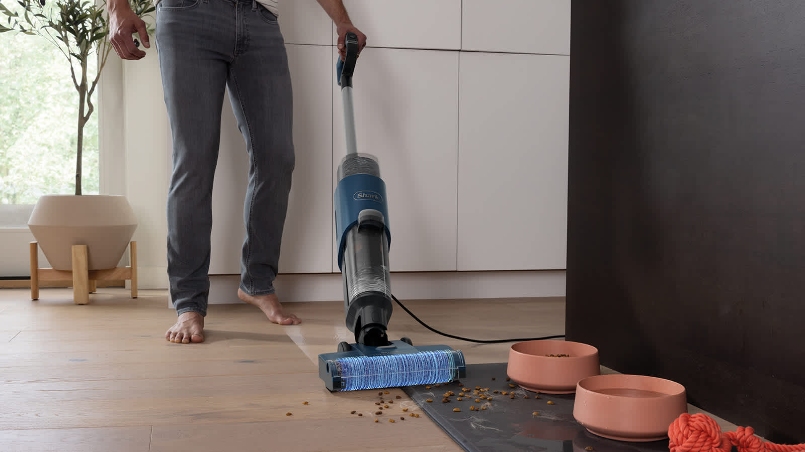 hombre limpiando la comida del perro por el suelo con la fregona el&eacute;ctrica shark hydrovac