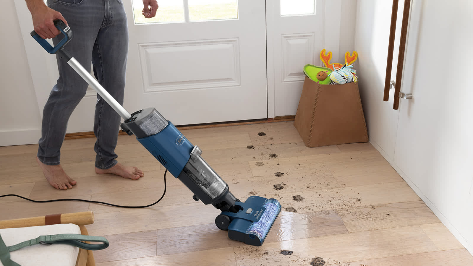 hombre limpiando huellas de perro humedas con la fregona el&eacute;ctrica shark hydrovac