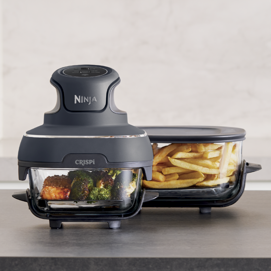 Ninja Crispi contenant du saumon et du brocoli avec un bac suppl&eacute;mentaire contenant des frites.