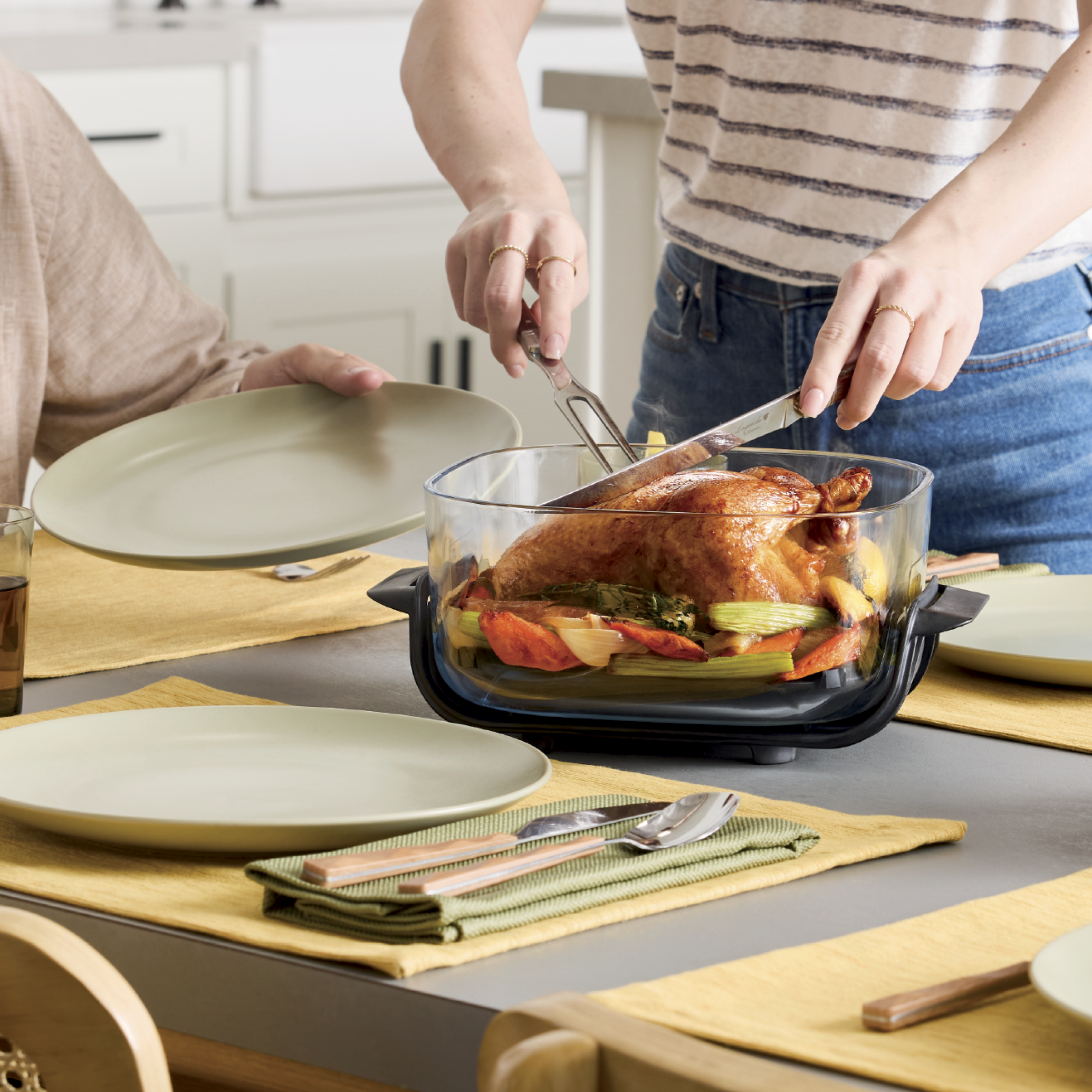 Personne d&eacute;coupant un poulet cuit dans le Ninja Crispi.