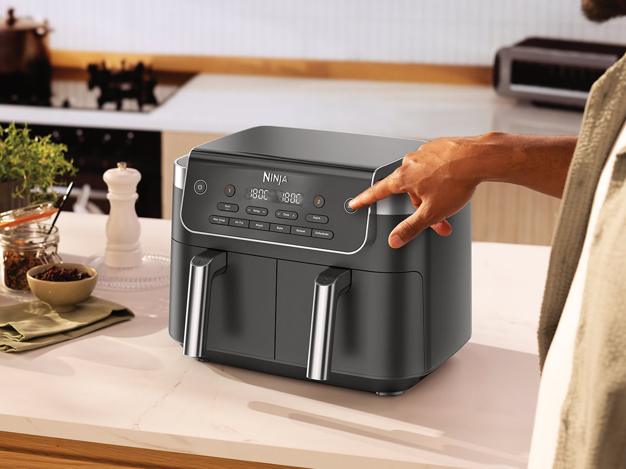 Air fryer sur une table présentant ses modes de cuisson.