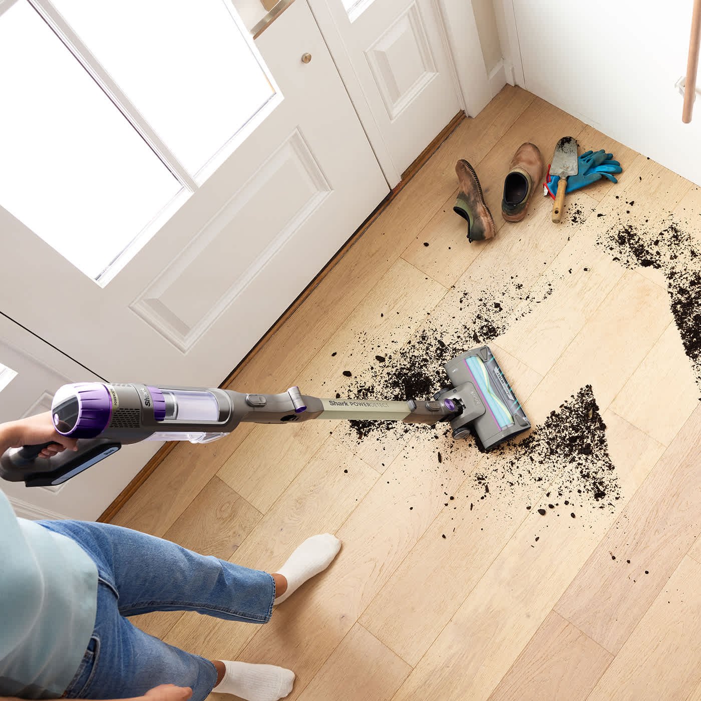 Women cleaning up mud in the hallway using the PowerDetect Cordless Vacuum Cleaner