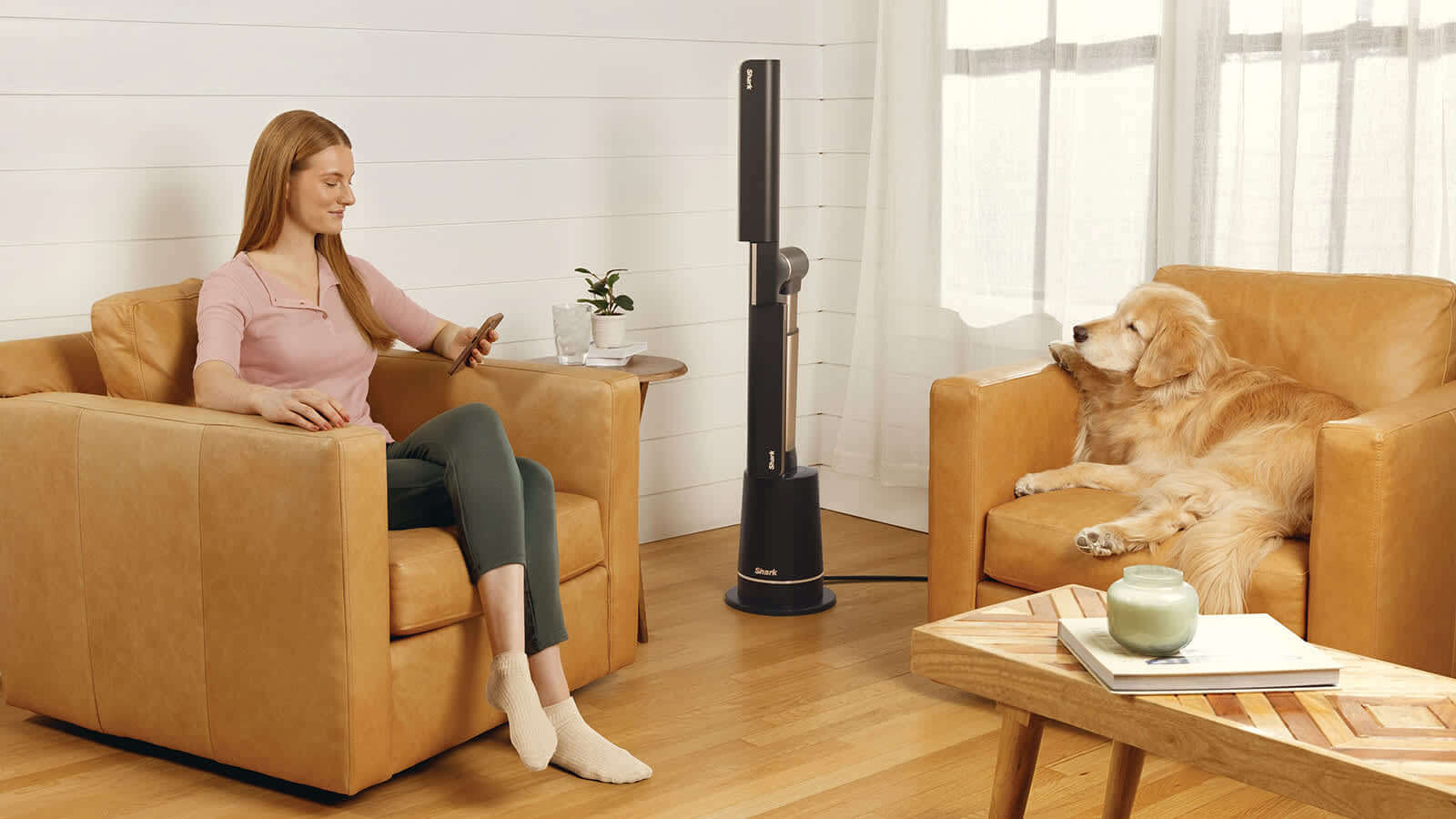 Image of woman and dog sat in the living room with the Shark TurboBlade fan