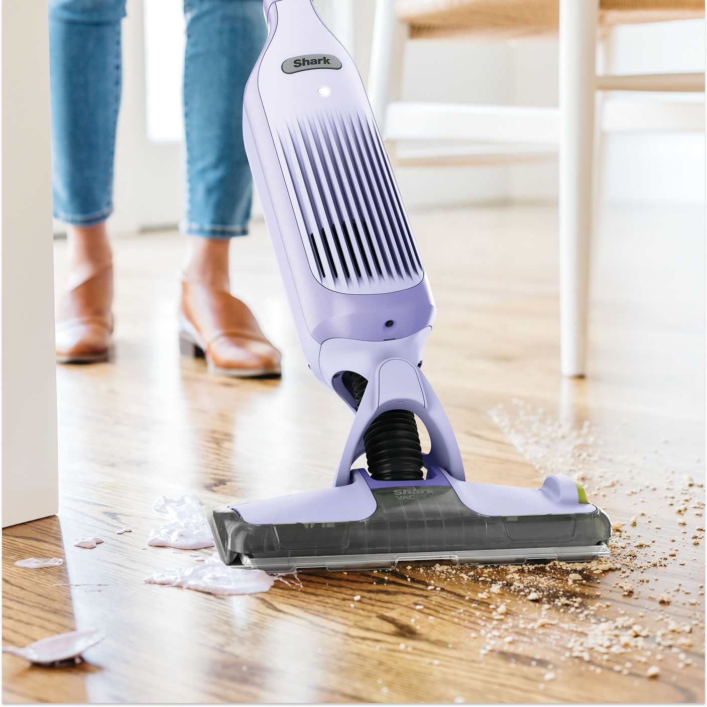 A women using the Shark StainStriker to clean up spills on a stairs runner